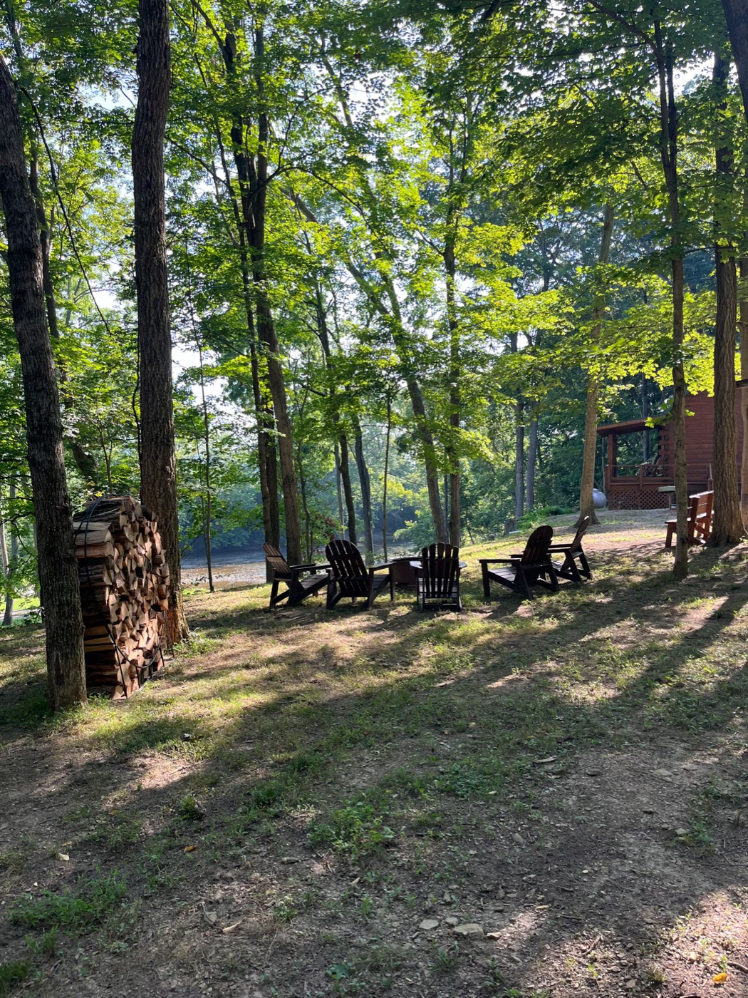 Adirondack chairs around the firepit in the woods