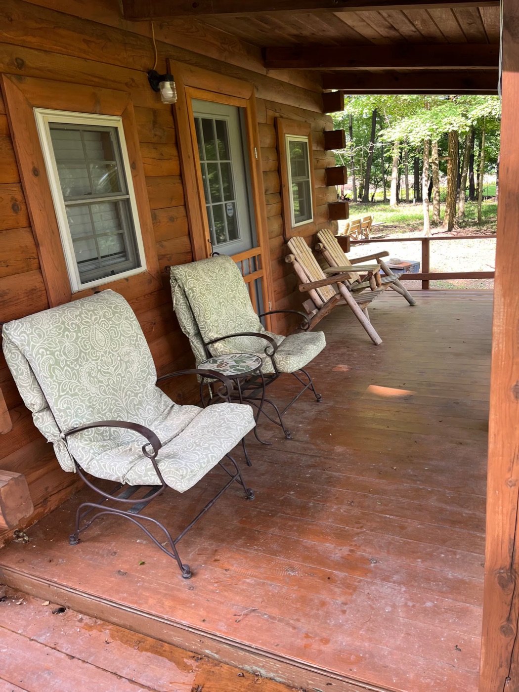 Covered porch with wicker seating overlooking the woods